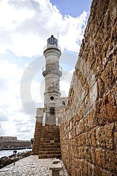 The lighthouse majestically rises above the wall separating the bay from the sea.