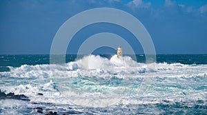 The lighthouse of the Mangiabarche shrouded by the waves of a mistral wind storm photo