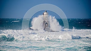 The lighthouse of the Mangiabarche shrouded by the waves of a mistral wind storm