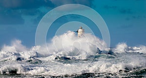 The lighthouse of the Mangiabarche shrouded by the waves of a mistral wind storm