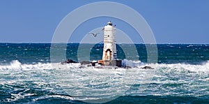 The lighthouse of the Mangiabarche shrouded by the waves of a mistral wind storm photo