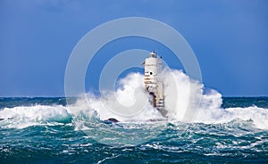 The lighthouse of the Mangiabarche shrouded by the waves of a mistral wind storm