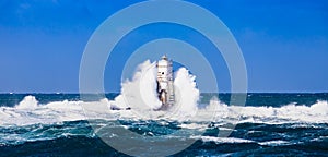 The lighthouse of the Mangiabarche shrouded by the waves of a mistral wind storm photo