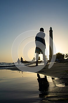 Lighthouse in Maspalomas, Gran Canaria, Spain at sunset with people and beach