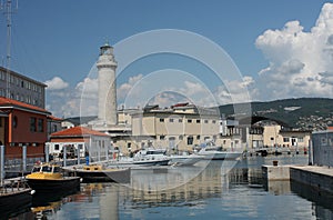 Lighthouse, motor boats in harbor in Trieste, Italy