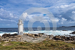 Lighthouse in Muxia on the Costa da Morte in Galicia, Spain. Cape Vilan in the background