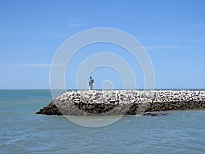 lighthouse in the ocean on a stone surface