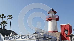 Lighthouse, palm trees and blue sky. Red and white beacon. Waterfront harbor village. California USA