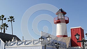 Lighthouse, palm trees and blue sky. Red and white beacon. Waterfront harbor village. California USA