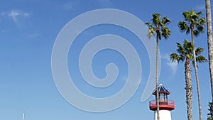 Lighthouse, palm trees and blue sky. Red and white beacon. Waterfront harbor village. California USA