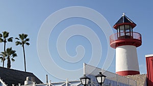 Lighthouse, palm trees and blue sky. Red and white beacon. Waterfront harbor village. California USA