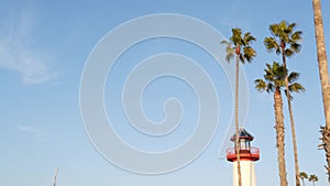 Lighthouse, palm trees and blue sky. Red and white beacon. Waterfront harbor village. California USA