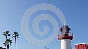 Lighthouse, palm trees and blue sky. Red and white beacon. Waterfront harbor village. California USA