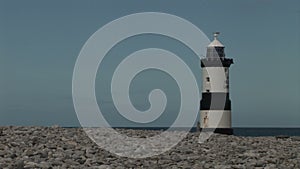 Lighthouse penmon point Beaumaris Wales looking over shingle beach