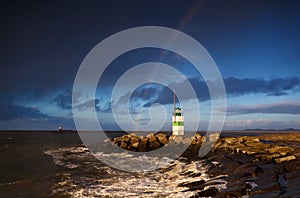 Lighthouse and rainbow over sea