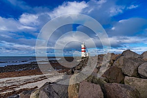 Lighthouse with red stripes wide angle with cloudscape