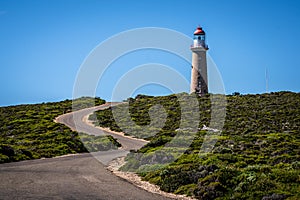 Lighthouse with red top and winding road at Cape du Couedic on Kangaroo island in Australia