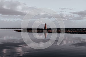 Lighthouse reflected in the waters of the lake under the cloudy sky in Kissimmee