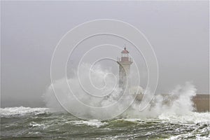Lighthouse in rough seas with crashing waves.