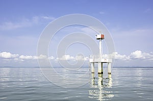 The lighthouse in the sea with eflection of water Background cloud and sky