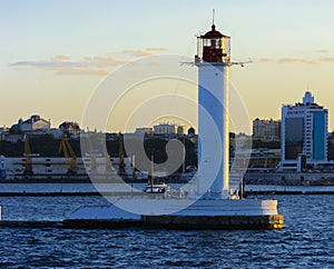 A lighthouse in the sea at the entrance to the port against the