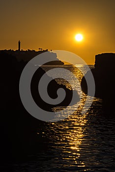 The lighthouse and the sea in front of Porto Colom at sunrise