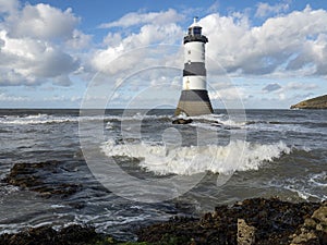 Lighthouse in the sea with sea surf