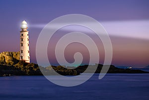 Lighthouse on sea sunset photo