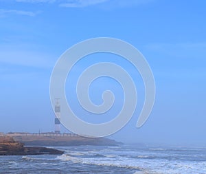Lighthouse at Seashore with Morning Mist in Air and Clear Blue Sky at Dwarka Point, Devbhumi Dwarka, Gujarat, India