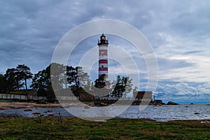 Lighthouse shines near the shore at sunset