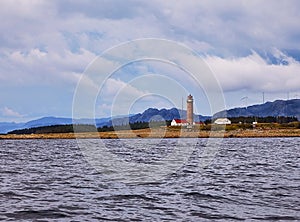 The lighthouse on the shore in Norway with mountains in background