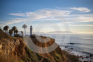 Lighthouse on the shore at sunset