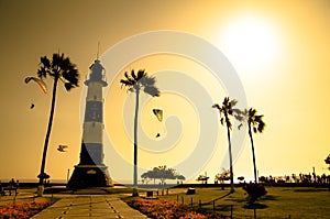 Lighthouse silhouette among golden sunset sea