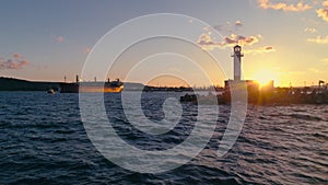 Lighthouse silhouette and sea at sunset in Varna