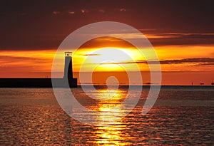 Lighthouse silhouette during sunrise over the baltic sea in gdynia, poland