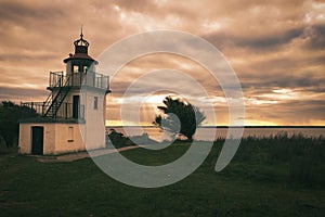 Lighthouse, Spodsbjerg Fyr in Huntsted on the coast of Denmark. Sun rays shining