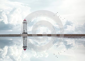 Lighthouse standing pool of water stunning dramatic storm clouds reflection reflected water sea steps up to building Wales sea