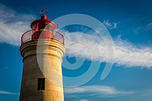 Lighthouse sunset with blue sky and clouds