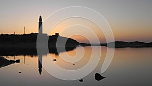 A lighthouse at sunset on a calm day