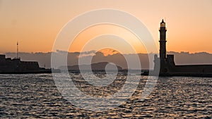 Lighthouse at sunset in the old Venetian harbor, city of Chania, Crete island