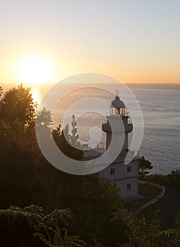 Lighthouse and sunset over the coast in San Sebastian