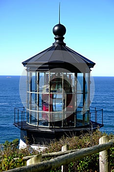 Lighthouse top with ocean in the background on a cloudless day