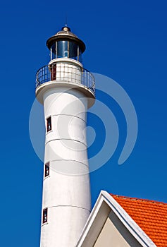 The lighthouse and top of the red roof with bright sky