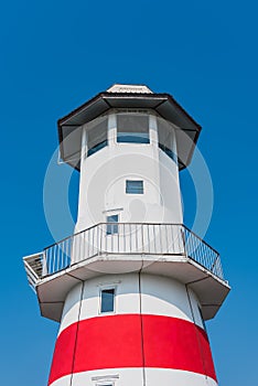 The lighthouse under clear blue sky in summer.