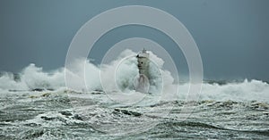 The lighthouse of the Mangiabarche shrouded by the waves of a mistral wind storm