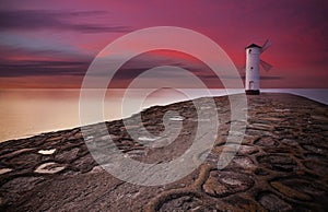 Lighthouse windmill with dramatic sunset sky