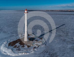 lighthouse is in winter on the river bank. View from above
