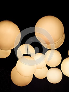 Lighting ball hanging from the ceiling on the black background.