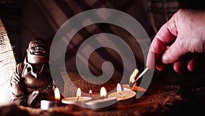 Lighting candle for buddhist meditation vigil with tea light candles bokeh