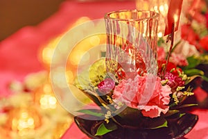 Lighting Candle and Offering Fresh Blossoming Flowers before Buddha Image believed to bring good merits to sincere Buddhist